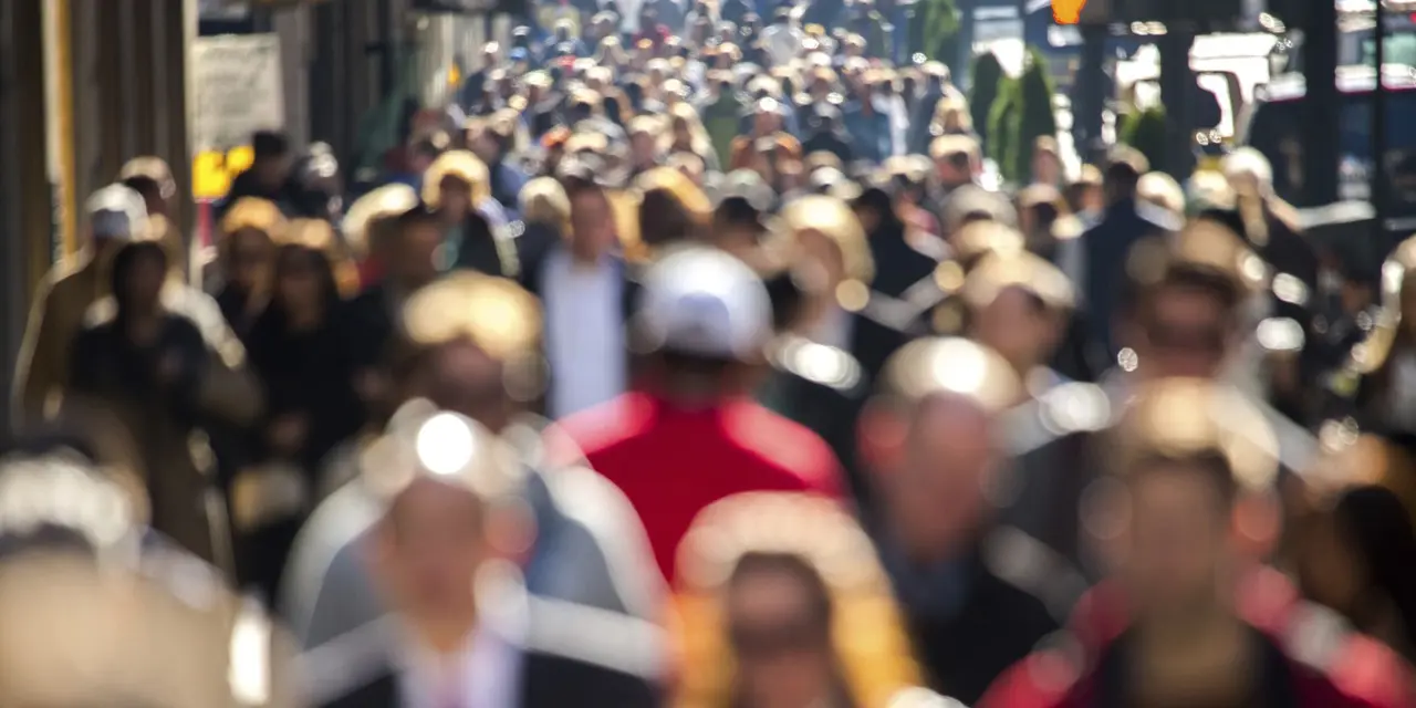 Anonymous crowd of people walking street