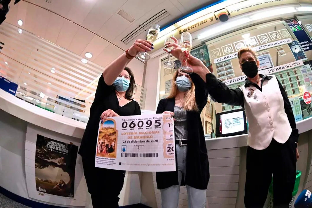 GRAF279. MADRID, 22/12/2020.- En la administraci&oacute;n de Loter&iacute;a del C.C.Hipercor de Alcal&aacute; de Henares celebran haber vendido d&eacute;cimos del n&uacute;mero 6095 agraciado con el segundo premio en el Sorteo Extraordinario de la Loter&iacute;a de Navidad que se celebr&oacute; este martes en el Teatro Real de Madrid. EFE/Fernando Villar