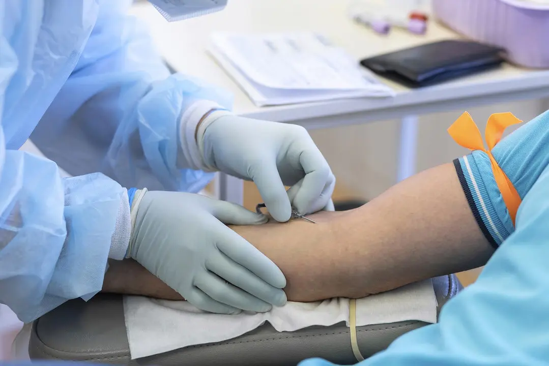 bone marrow donation. blood transfusion. hand in medical glove injects needle, blood sampling from a vein. intravenous medication
