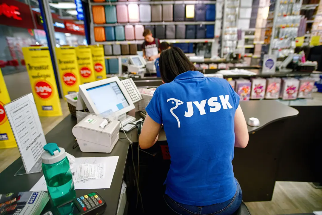 Minsk, Belarus. Jun 2019. JYSK store. Shop assistant, female cashier using digital device for payment. JYSK is the largest Danish retailer, international chain that sells everything for home.