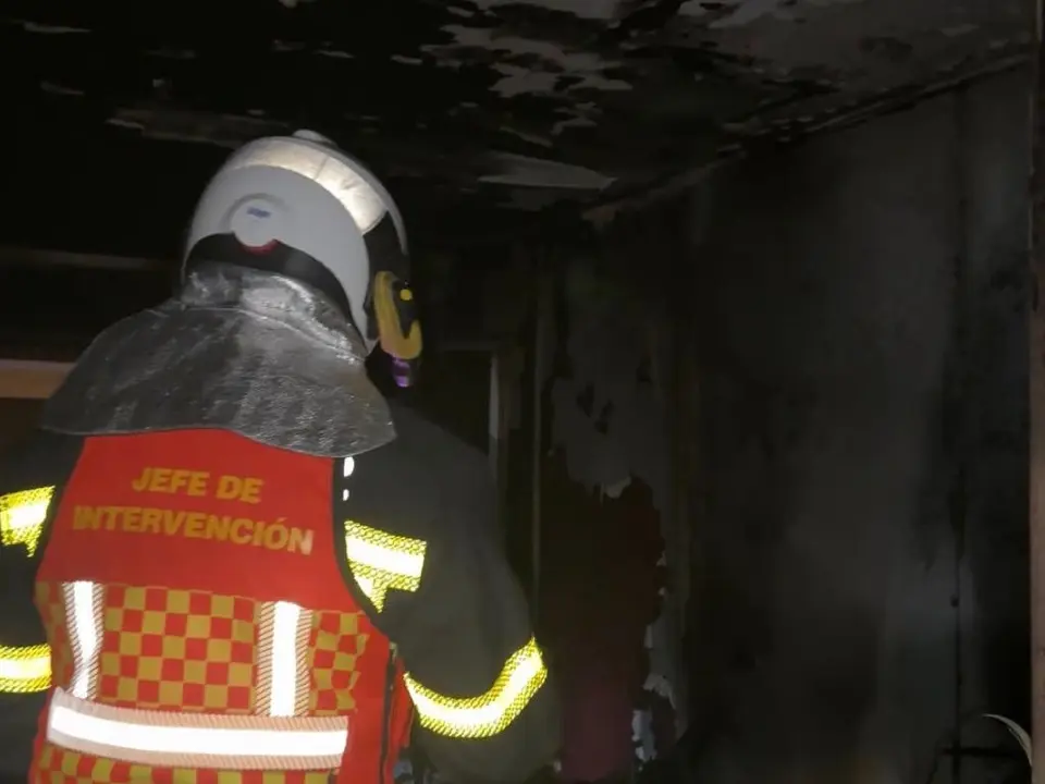 Un bombero inspecciona los da&ntilde;os tras un incendio en Collado Villalba.