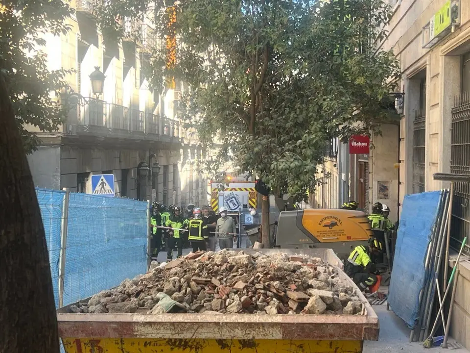 Bomberos y gu&iacute;as caninos rastrean los escombros en Madrid tras un derrumbe.