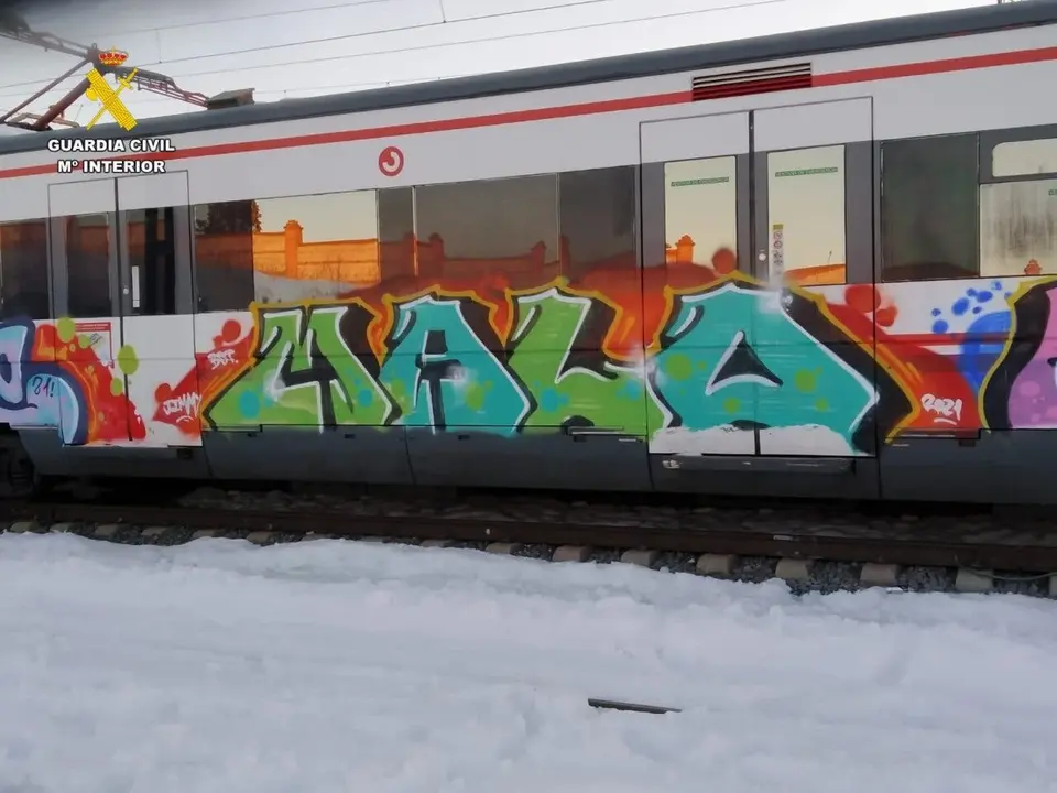 Un tren de Cercan&iacute;as en Madrid con grafiti colorido. La imagen muestra el arte urbano en el transporte p&uacute;blico.