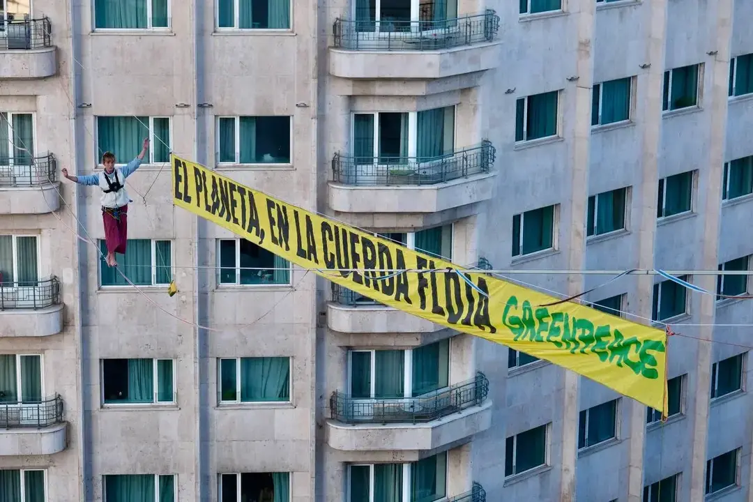 Activistas de Greenpeace realizan una protesta en altura para exigir justicia clim&aacute;tica.