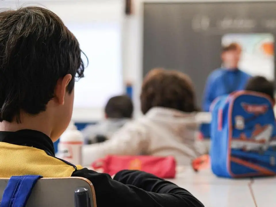 Un ni&ntilde;o presta atenci&oacute;n en clase mientras se prepara la admisi&oacute;n escolar.