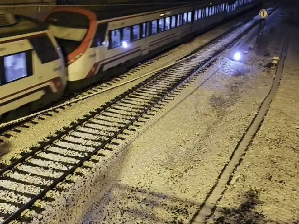 Un tren circula por la v&iacute;a nevada en el Corredor del Henares.