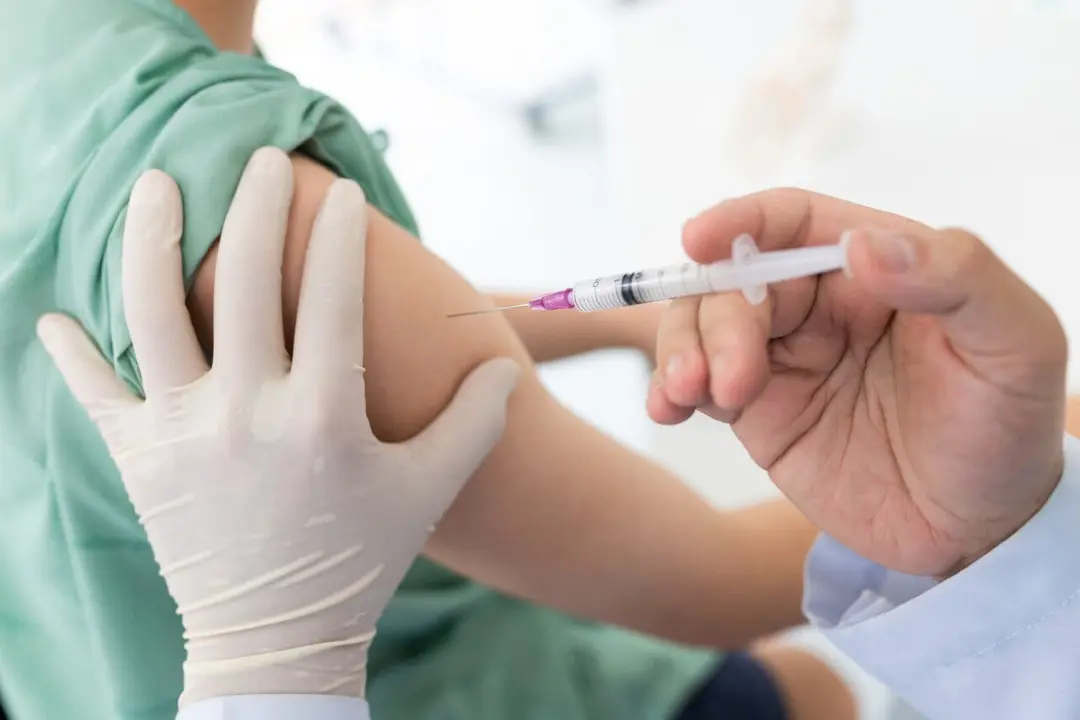Close up of a Doctor making a vaccination in the shoulder of patient, Flu Vaccination Injection on Arm, coronavirus, covid-19 vaccine disease preparing for human clinical trials vaccination shot.