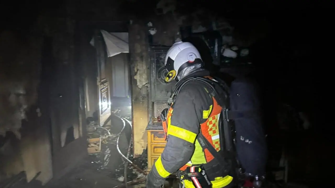 Un bombero examina los da&ntilde;os tras un incendio en Chapiner&iacute;a. Tres personas fueron atendidas por humo.