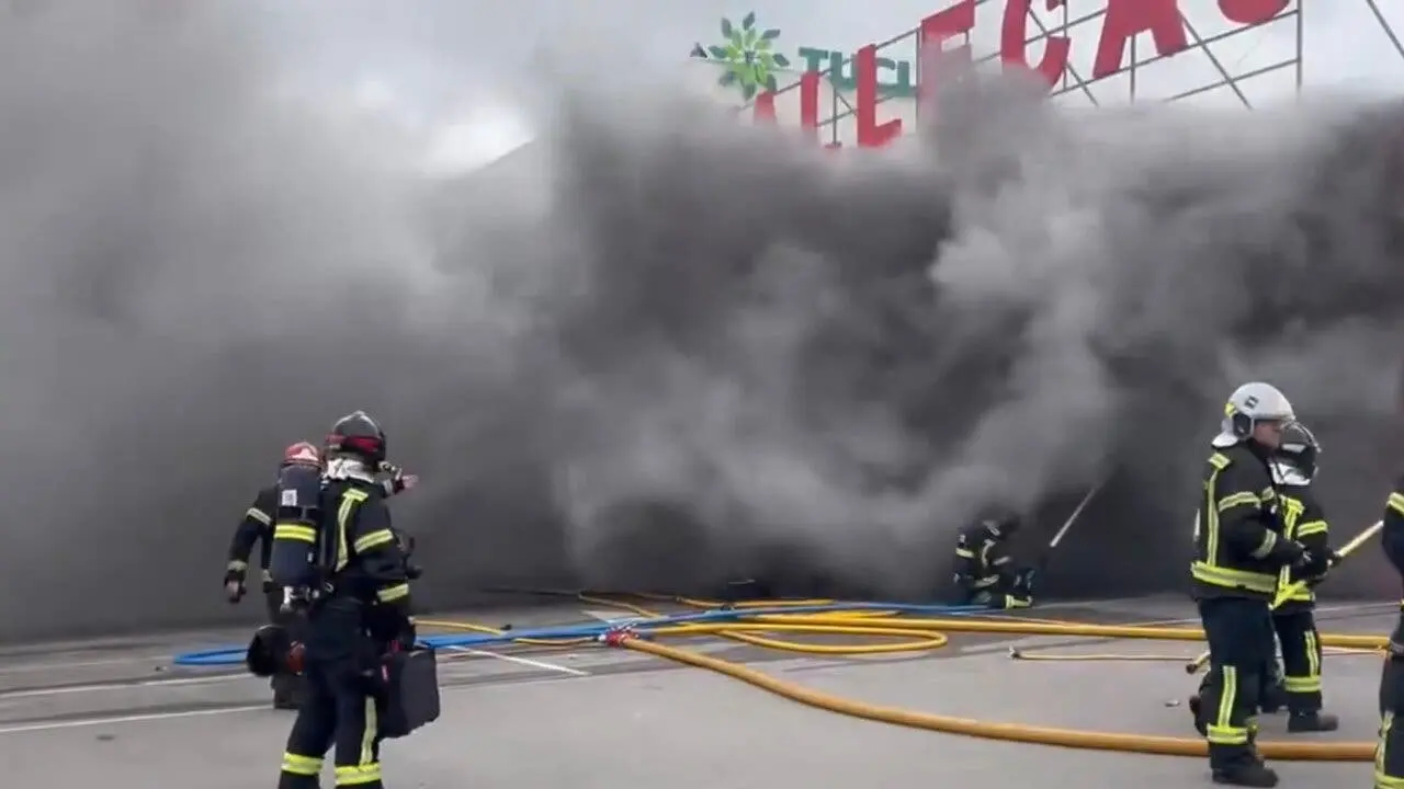 Un incendio en un bazar en Villaverde a Vallecas genera una gran columna de humo negro. Bomberos trabajan en la extinci&oacute;n.