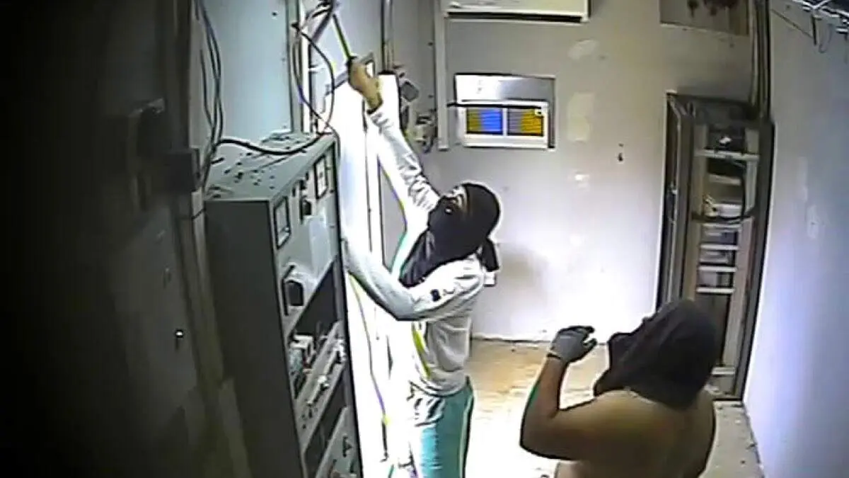 Los detenidos captados por las c&aacute;maras de seguridad manipulando el cableado en el interior de un repetidor de telefon&iacute;a. GUARDIA CIVIL