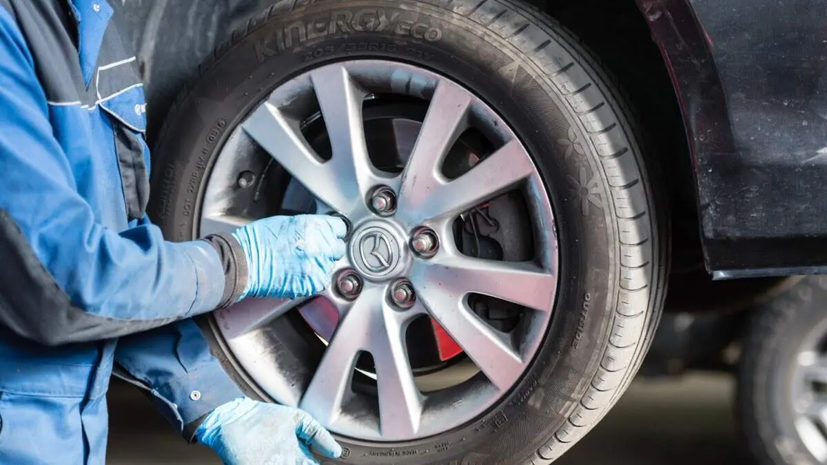 Mec&aacute;nico revisando la presi&oacute;n de un neum&aacute;tico en un veh&iacute;culo. SHUTTERSTOCK