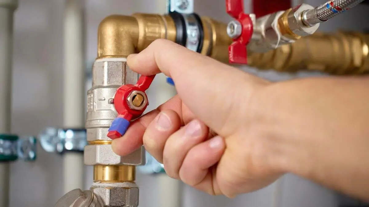 Manipulaci&oacute;n de una v&aacute;lvula en un sistema de tuber&iacute;as de agua, en una imagen de archivo. SHUTTERSTOCK