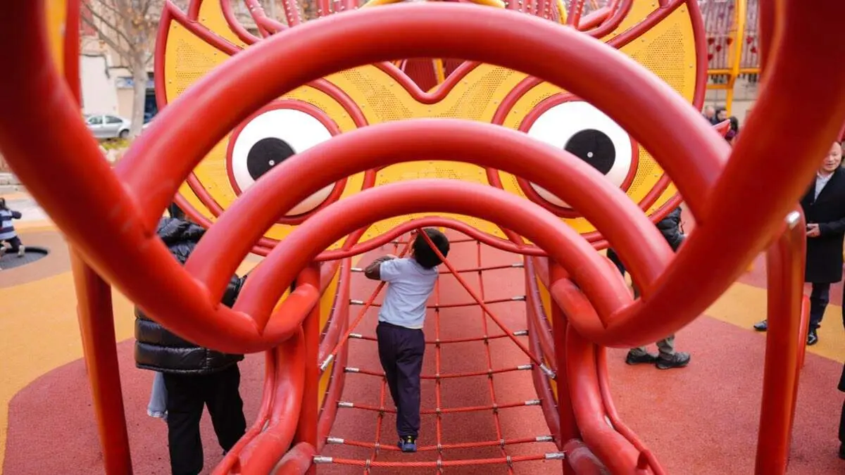 Ni&ntilde;o jugando en la estructura del drag&oacute;n del parque infantil de la plaza de las Tizas. AYUNTAMIENTO DE MADRID
