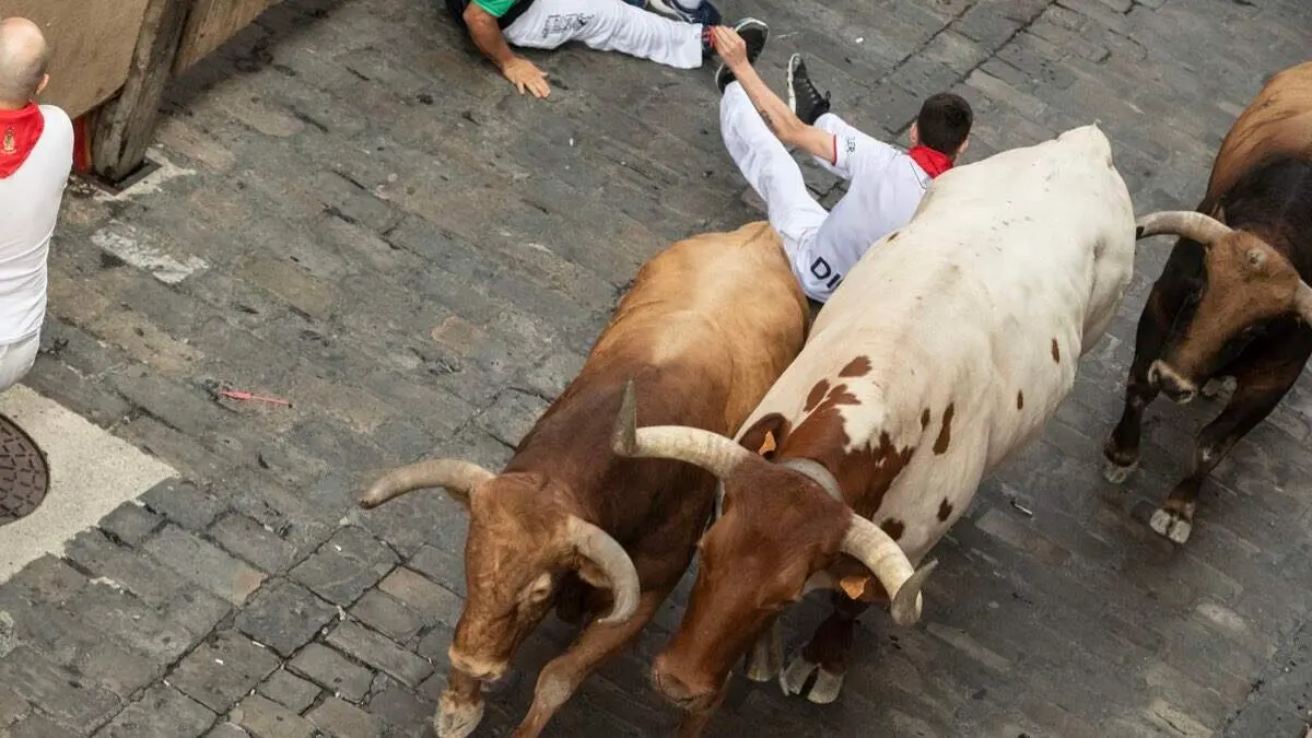 Un corredor en el suelo durante el sexto encierro de San Ferm&iacute;n 2026. AYTO. DE PAMPLONA