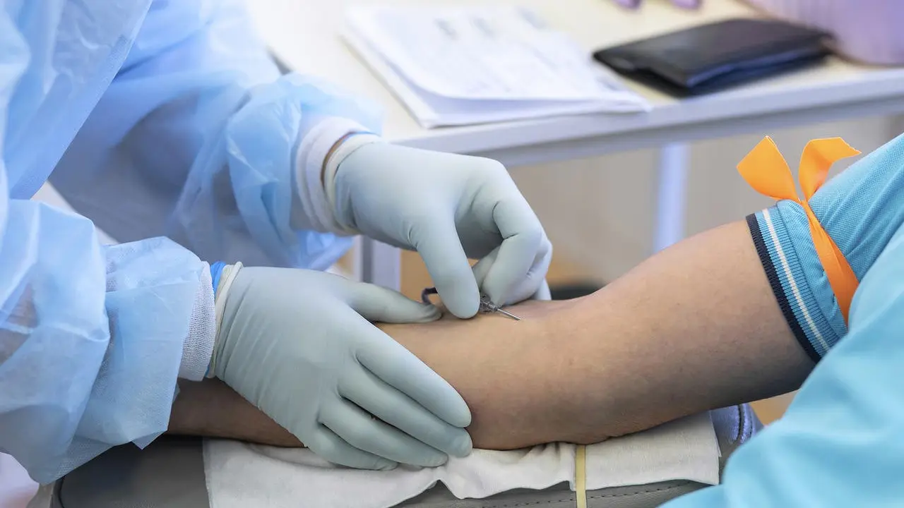 bone marrow donation. blood transfusion. hand in medical glove injects needle, blood sampling from a vein. intravenous medication
