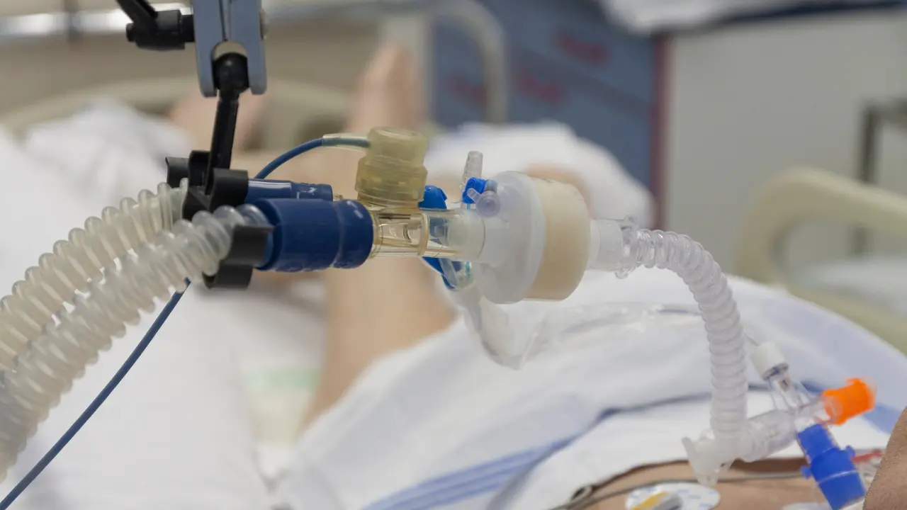 Respiratory connection tube, HME filter and suction catheter, patient connected to medical ventilator in ICU in hospital.
