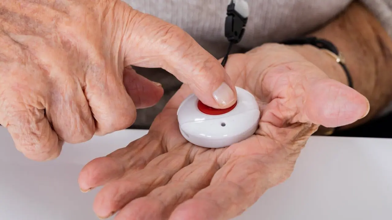 Close-up Of Senior Woman Pressing Alarm Button For Emergency