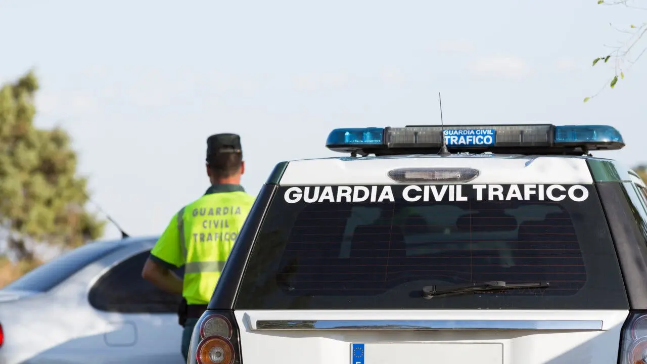 Agent of the civil traffic police with his patrol car in Madrid, Spain.