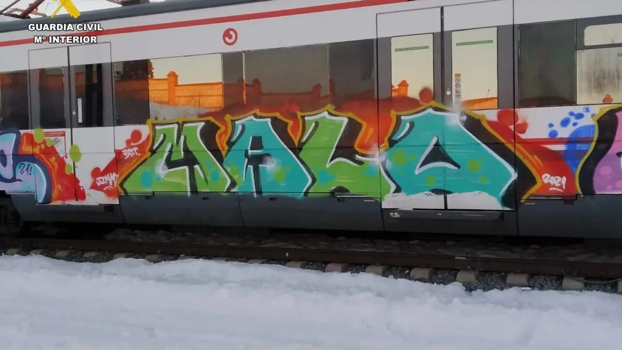 Un tren de Cercan&iacute;as en Madrid con grafiti colorido. La imagen muestra el arte urbano en el transporte p&uacute;blico.