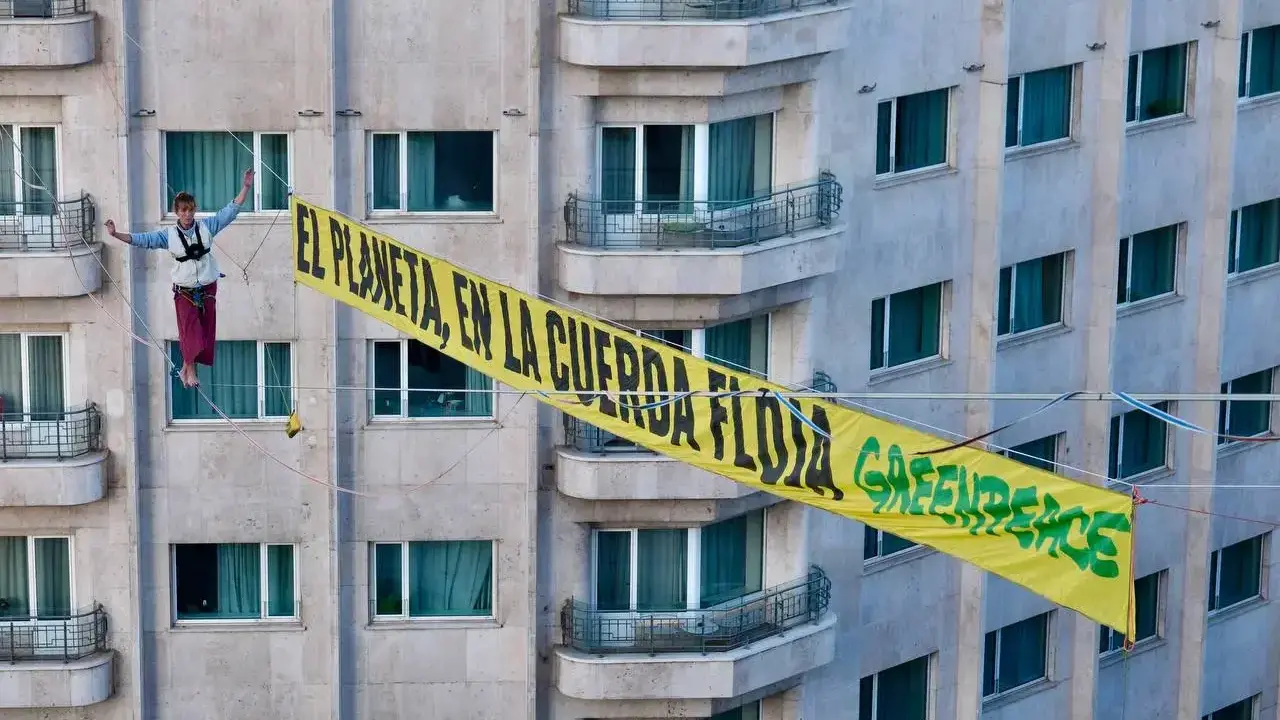 Activistas de Greenpeace realizan una protesta en altura para exigir justicia clim&aacute;tica.