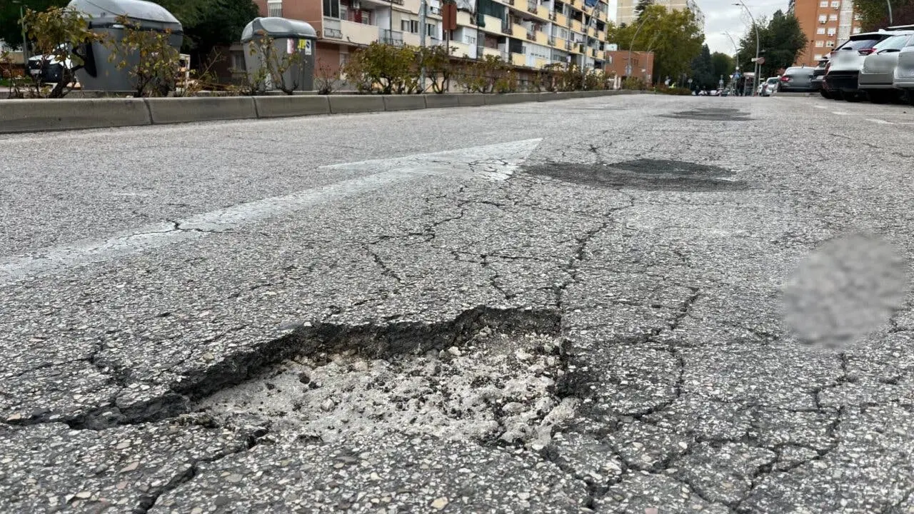 La calle muestra baches que requieren atenci&oacute;n en Alcal&aacute; de Henares.
