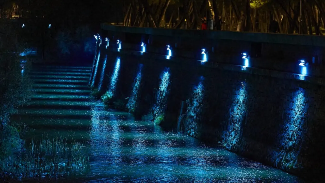 El r&iacute;o Manzanares brilla con luces azules en Navidad, creando una atm&oacute;sfera m&aacute;gica.