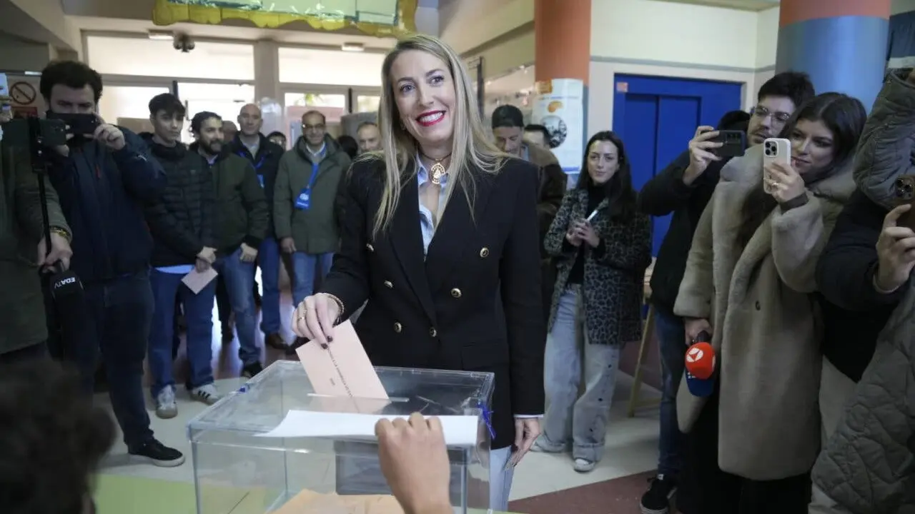 La candidata del PP vota mientras es observada por otros.