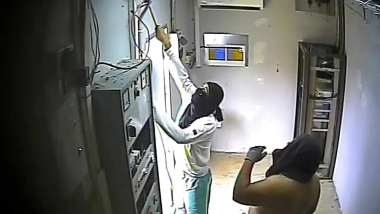 Los detenidos captados por las c&aacute;maras de seguridad manipulando el cableado en el interior de un repetidor de telefon&iacute;a. GUARDIA CIVIL