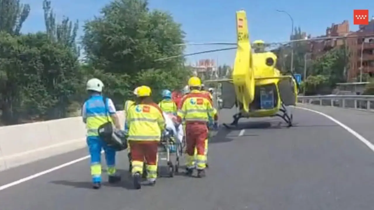 Sanitarios del SUMMA trasladan al motorista herido hasta el helic&oacute;ptero sanitario. 112 COMUNIDAD DE MADRID