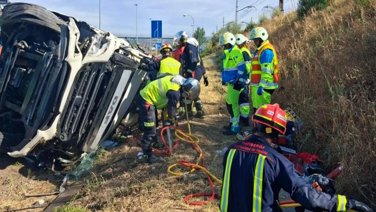 Los Bomberos de la Comunidad de Madrid durante el rescate del camionero tras el semivuelco de un tr&aacute;iler en la A-6, a la altura de Las Rozas. 112 COMUNIDAD DE MADRID.