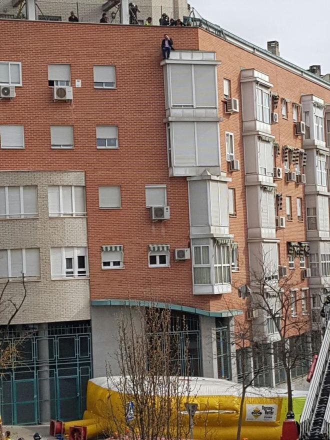 El suicida habla por el móvil mientras una colchoneta la espera abajo en caso de caída (El Mundo).