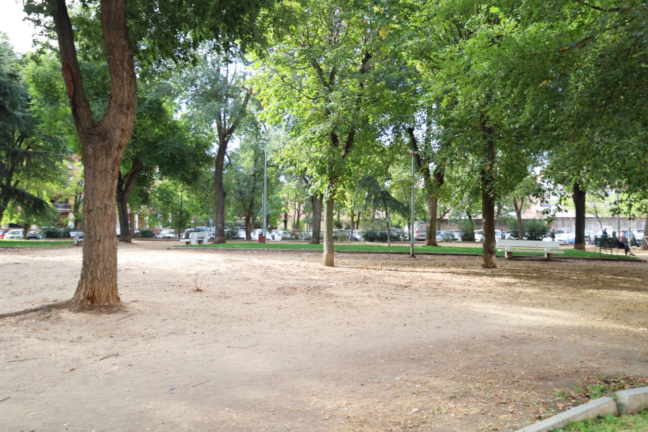 Vista de la Plaza Príncipe Carlos en Alcalá de Henares con árboles y bancos.