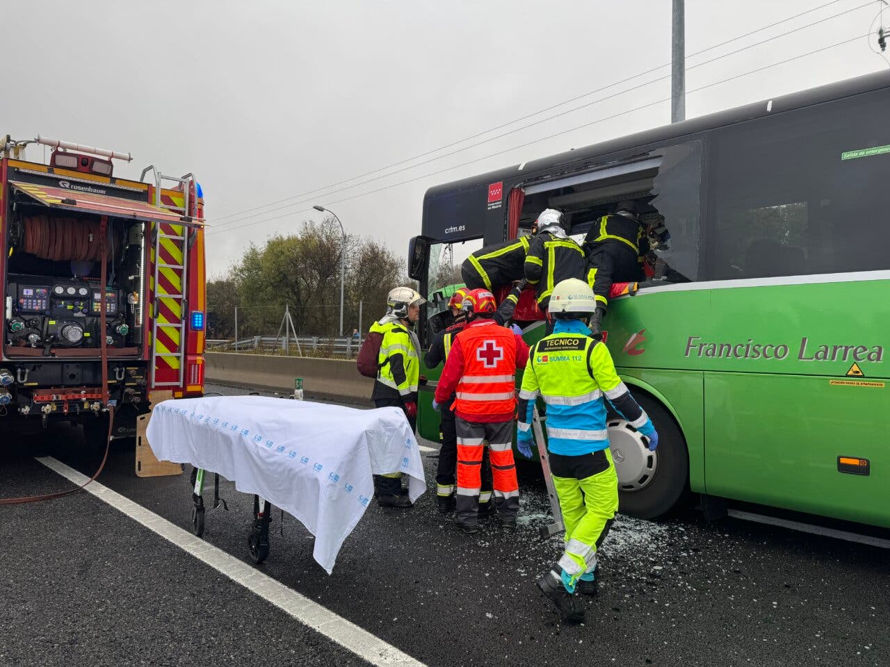 Rescatistas atendiendo a heridos en un accidente de autobús en la A-6.