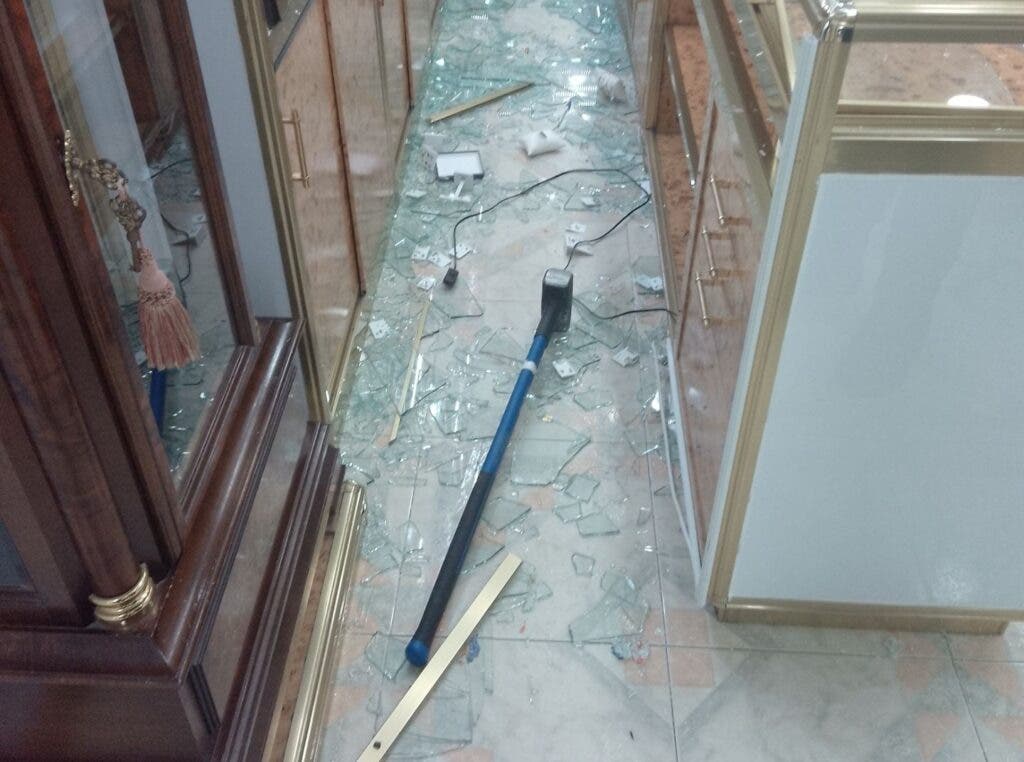 Interior de una joyería con cristales rotos y herramientas de robo