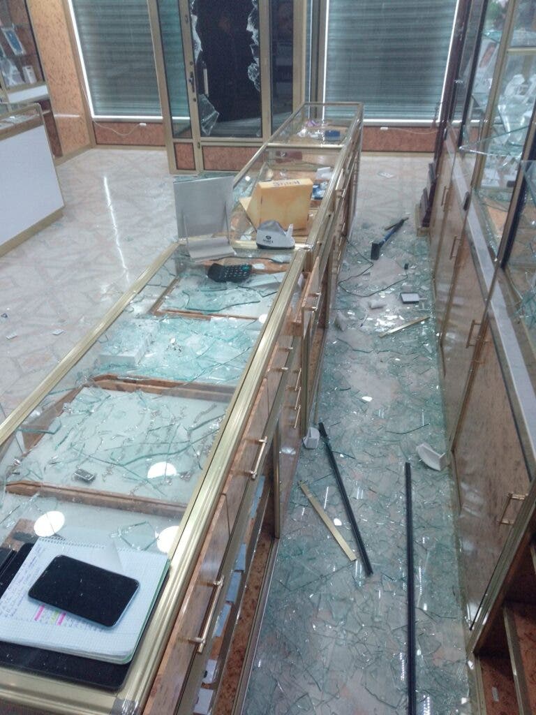 Interior de una joyería con vitrinas destrozadas y cristales rotos