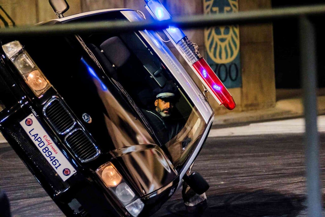 Coche de policía inclinado con luces encendidas en Parque Warner Madrid.