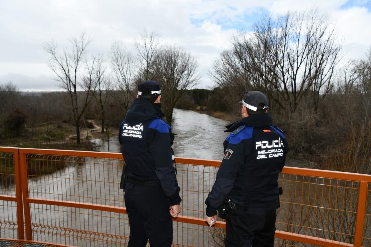 Policías observando el río Jarama durante una alerta de inundación