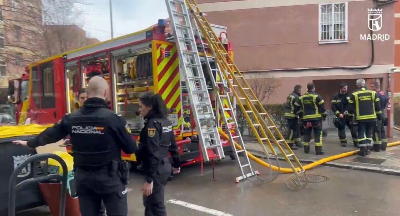 Bomberos y policías en la escena de un incendio en Latina, Madrid.