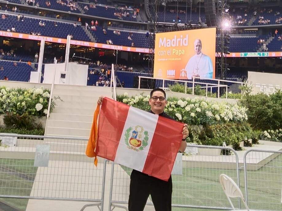 El párroco Daniel Acedo sostiene una bandera de Perú en el estadio Santiago Bernabéu durante el encuentro con León XIV. DIÓCESIS DE ALCALÁ