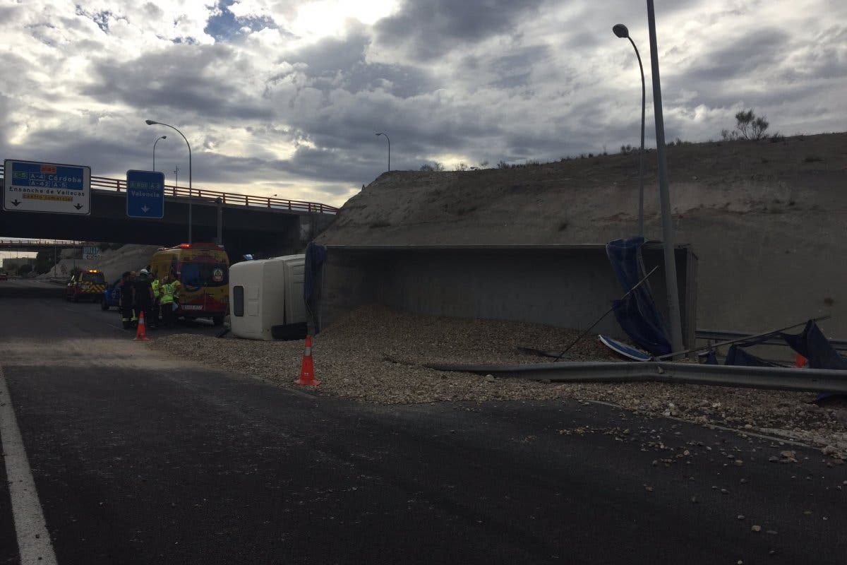 Aparatoso vuelco de un camión de arena en la M-45