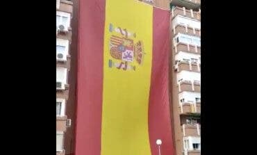Vecinos del barrio del Pilar, en Madrid, despliegan una enorme bandera de España