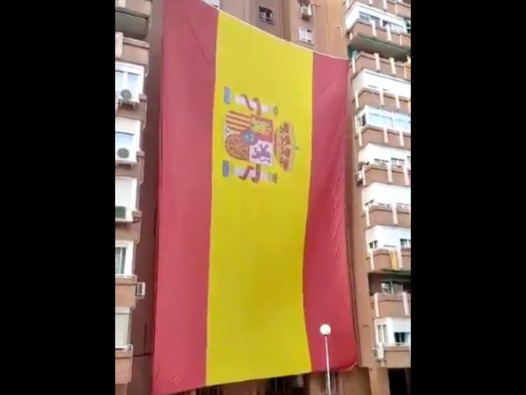 Vecinos del barrio del Pilar, en Madrid, despliegan una enorme bandera de España