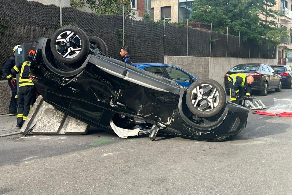 Herido el conductor de un coche tras chocar con otro y volcar en plena calle en Madrid 