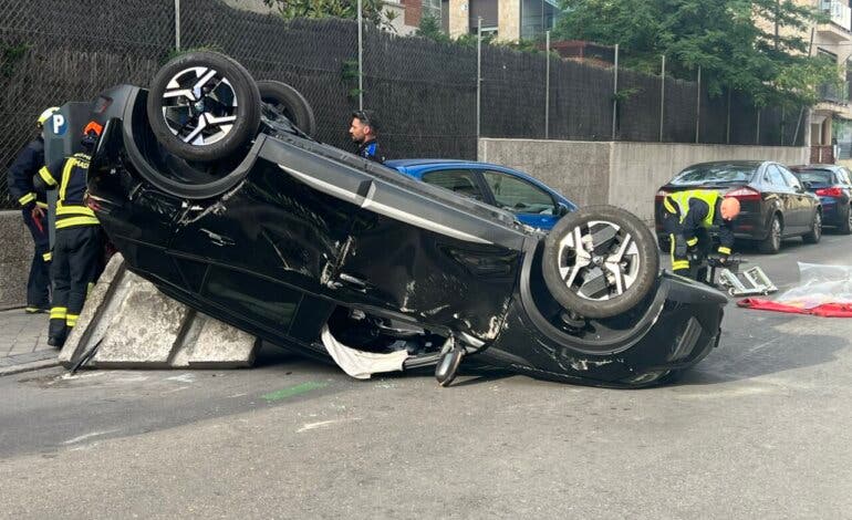Herido el conductor de un coche tras chocar con otro y volcar en plena calle en Madrid 