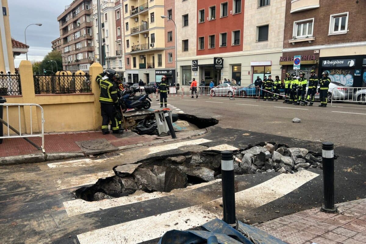 Un gran socavón se traga dos motos y varios contenedores en Madrid 