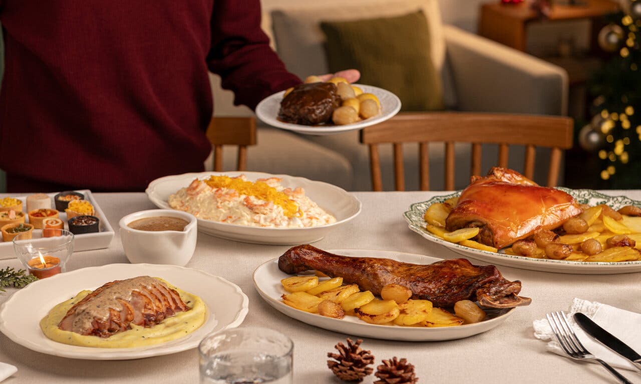 Mesa con platos navideños de Mercadona, incluyendo cochinillo y cordero.