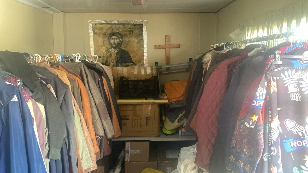Interior de un espacio de Cáritas con ropa y artículos para ayudar a la comunidad.
