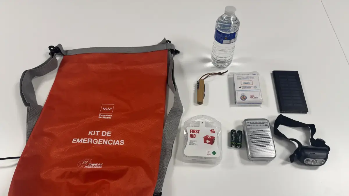 Kit de emergencias con radio, botiquín y linterna sobre una mesa