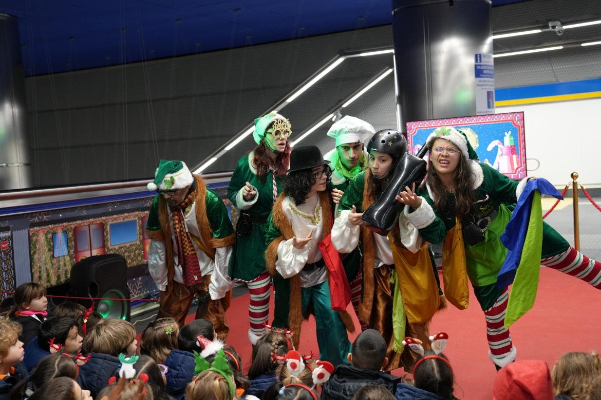 Actores disfrazados de elfos en un evento navideño para escolares