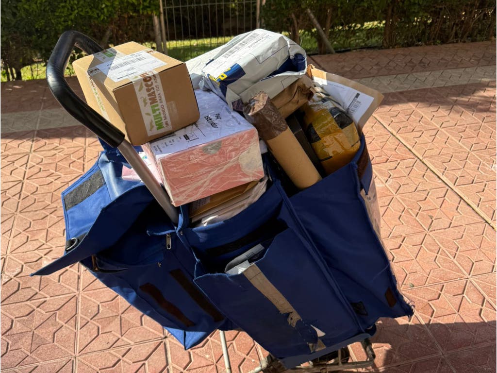 Carro de reparto de Correos lleno de paquetes y cartas